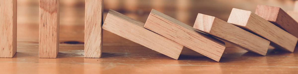 A cut out image of a series of wooden blocks falling like dominoes